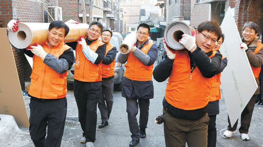 12일 서울 창신동에서 한화그룹 신임임원 40명이 소외계층 가정을 방문해 벽지, 장판 교체 등 주거 환경 개선작업을 하고 있다.     한화그룹 제공